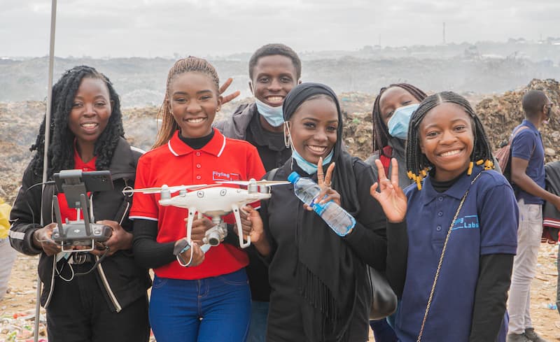 Students smiling holding a drone