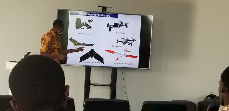 An instructor presenting information about drones from a slide on a screen
