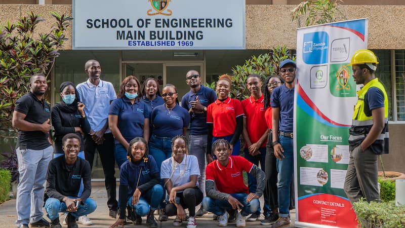 Zambia Flying Labs and training participants standing in front of the School of Engineering Main Building