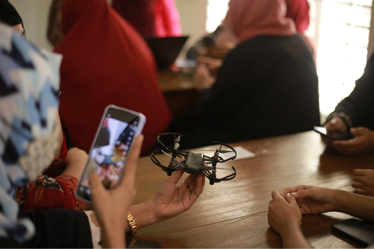 a female participant taking a photo of a drone with her phone